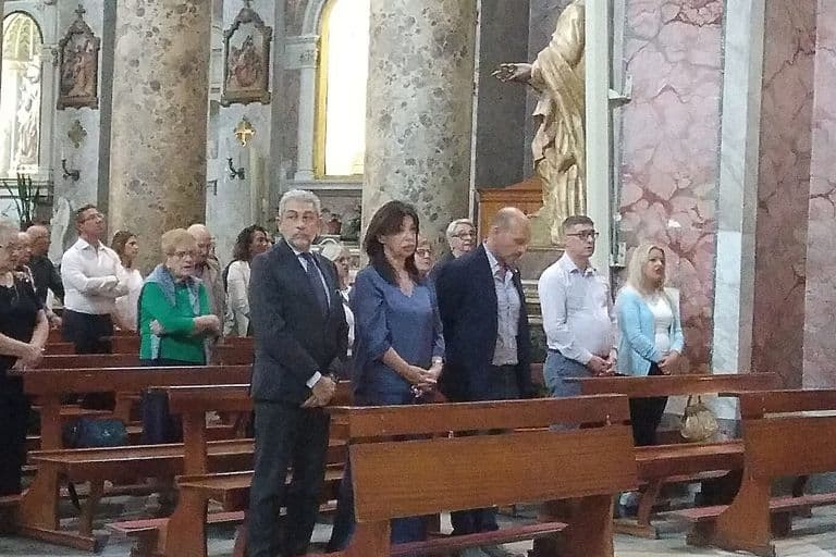 I fedeli in piedi nei primi banchi durante la celebrazione