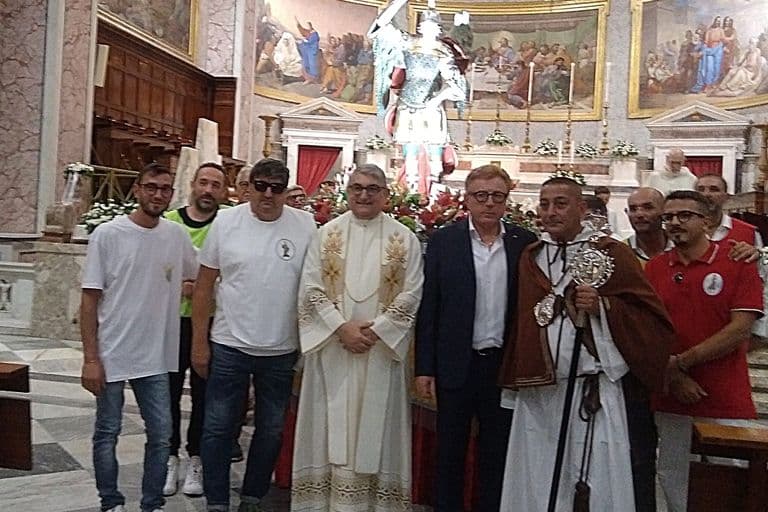 Foto di gruppo davanti al simulacro di San Michele al termine della Messa